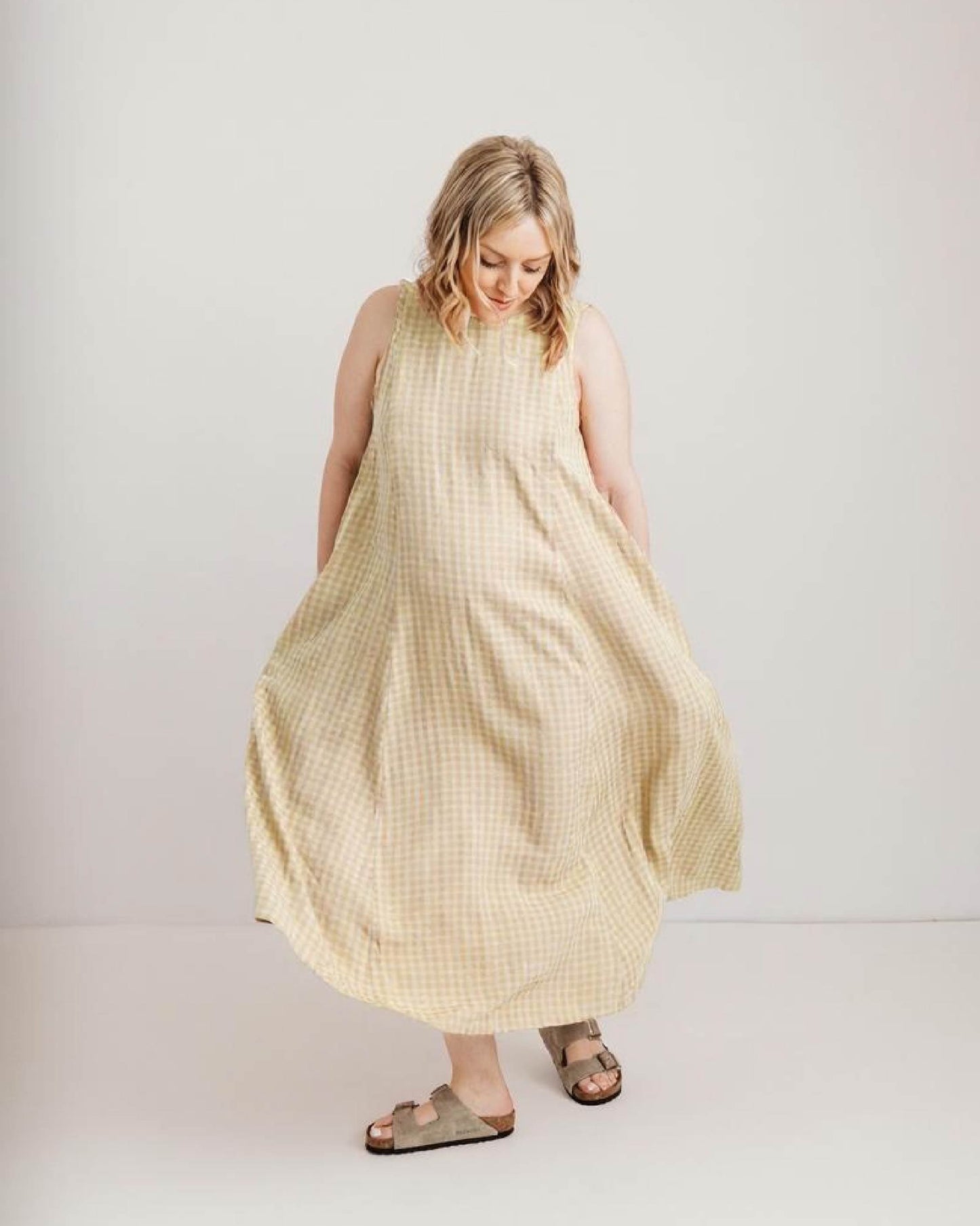 Image of a woman wearing a lucy dress from Journy in yellow check